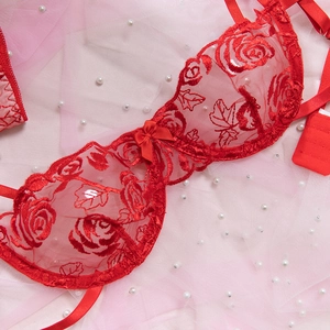 Dettaglio del ricamo rosa rossa sul reggiseno in pizzo con elegante fiocco di nastro