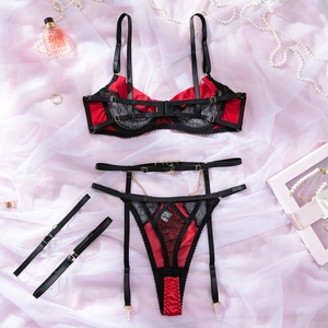Detail of red satin and black lace lingerie set with gold chains and metallic rings