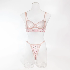 Detail of light pink floral lingerie set showing delicate red flower patterns and straps