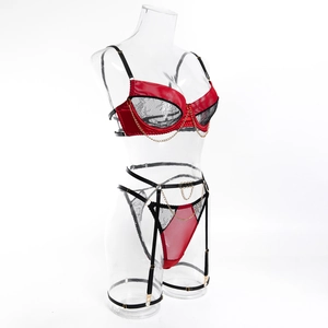 Detail of sexy red satin and black lace lingerie set with gold chain and underwire cups