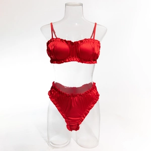 Détail d'un ensemble de lingerie en satin rouge avec bords à volants et culotte haute