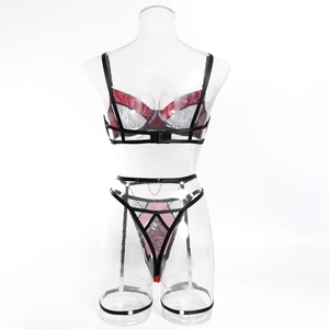 Detail of red lace lingerie set with black straps and golden metal rings on a model