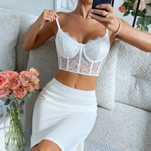 Détail du haut bustier en dentelle blanche avec bords festonnés et jupe moulante assortie