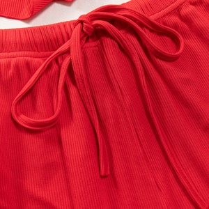 Dettaglio del pigiama in maglia a coste rosse con elastico in vita e coulisse abbinata