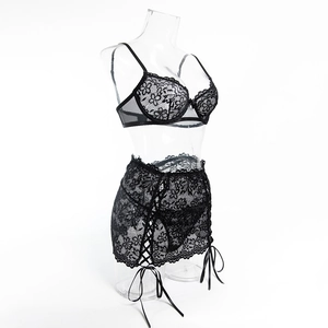 Dettaglio del set di lingerie in pizzo nero con lacci incrociati e fiocchi di nastro
