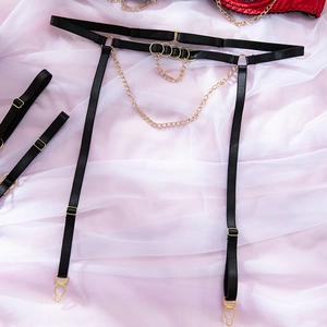 Detailed view of sexy black garter belts with golden O-rings and delicate metal chains