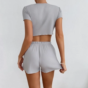 Dettaglio del tessuto a costine grigio chiaro sul crop top a maniche corte e pantaloncini con laccio