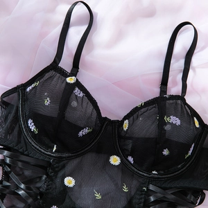 Macro detail of black sheer mesh bodysuit with floral embroidery and side lacing