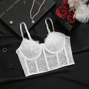 Détail d'un bustier en dentelle blanche avec baleines de corset et motifs floraux