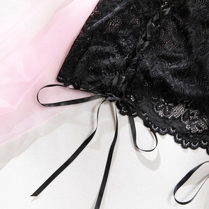 Dettaglio macro di lingerie in pizzo nero con nastro stringato e ricamo floreale fine