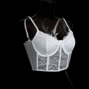Détail du haut corset en dentelle blanche avec baleines et bordures délicates en dentelle