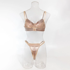 Detailed view of champagne satin bra and thong set on a transparent mannequin