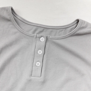 Dettaglio del top del pigiama in maglia a coste grigie con scollo Henley e tre bottoni
