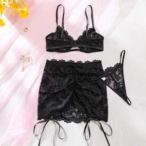 Set di lingerie in pizzo nero con reggiseno, minigonna e perizoma su sfondo bianco puro