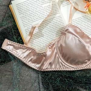 Detail of champagne satin bra with adjustable straps and elegant French aesthetic