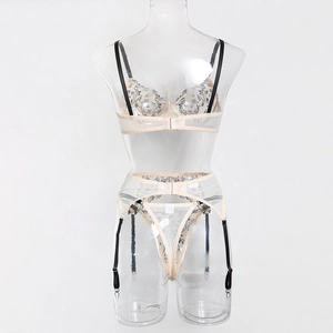 Détail de la broderie florale sur un ensemble de lingerie en mesh avec jarretelles