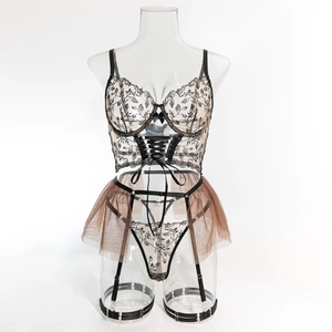 Detailansicht eines transparenten Mesh-Bodys mit schwarzer Blumenstickerei und Schnürung