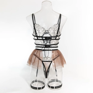 Detail der Blumenstickerei am Netz-Bodysuit mit Harness-Gurten und Spitzen-Strapsen