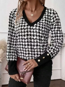 Detail of V-neck houndstooth top showing black cuffs with decorative gold buttons