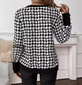 Detail of classic houndstooth knit cardigan with black ribbed hem and golden cuff buttons