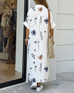Detail view of white floral shirt dress featuring rolled short sleeves and side slits