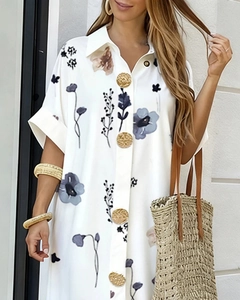 Detail of vintage embossed gold buttons on a white floral short-sleeved shirt dress