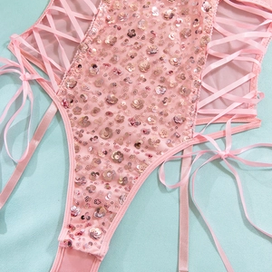 Dettaglio body con paillettes rosa con inserti in rete e allacciatura in nastro di seta
