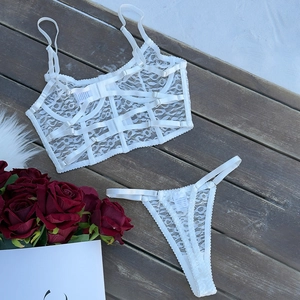 Detailed close-up of white floral lace lingerie set with corset boning and sheer fabric