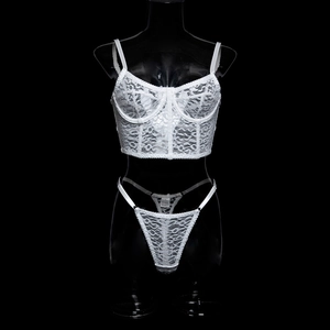Detail of white lace bustier set with floral embroidery on black mannequin