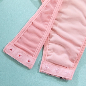 Dettaglio di body in rete rosa con bottoni a pressione e decorazioni con paillettes lucide