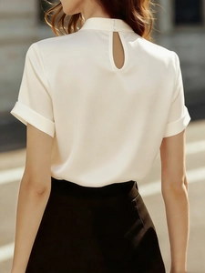 Detail view of the back teardrop cutout and stand collar on the off-white satin blouse