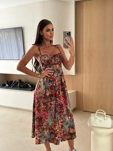 Detail of floral print dress featuring slim straps with elegant decorative shoulder bows