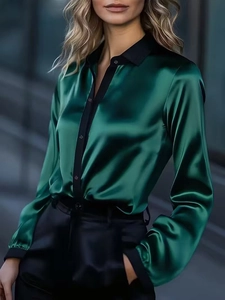 Detail of emerald green satin shirt featuring a contrast black collar and button placket