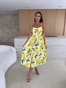 Detail of white midi dress with lemon print, bow straps and front buttons
