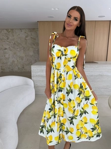 Detail of summer dress featuring vibrant yellow lemon prints and adjustable tie straps