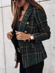 Detail of green plaid tweed jacket with classic lapel and gold-tone metal buttons