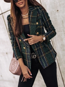 Macro detail of dark green plaid tweed blazer with elegant gold embossed metal buttons