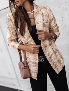 Close-up detail of beige plaid tweed blazer with elegant embossed golden buttons