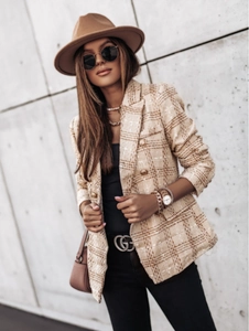 Detail of plaid tweed blazer with classic buttons and textured fabric weave