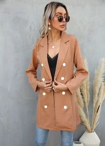Close-up of a camel double-breasted long blazer with large white buttons and notch lapels