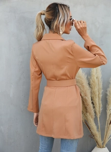 Detail of camel long blazer with a matching waist belt and back tailoring line