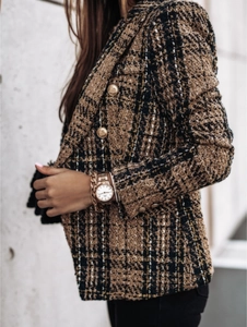 Close-up of textured brown tweed blazer with detailed golden embossed metal buttons