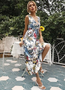 Macro detail of summer V-neck maxi dress with tropical floral print in outdoor garden setting