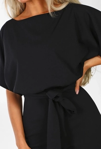 Detail of black off-shoulder jumpsuit with waist tie and loose sleeves on white background