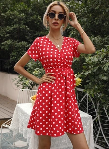 Détail d'une robe rouge à pois avec col en V et ceinture à nœud pour un look d'été