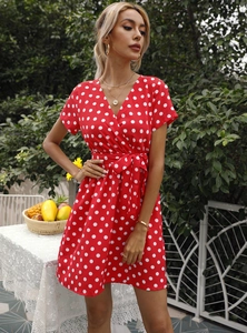 Vue détaillée de la robe rouge à pois avec col en V classique et nœud à la taille