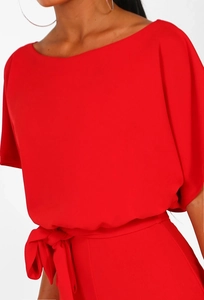 Detail of red off-shoulder romper with batwing sleeves and waist tie bow decoration