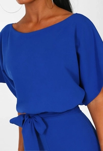 Detail of royal blue short sleeve jumpsuit showing waist tie and chiffon fabric texture