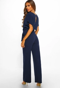 Detail of navy blue jumpsuit showing flutter sleeves, waist tie and open back design