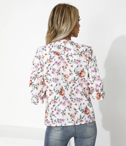 Vista dettagliata del retro di una camicetta a fiori con maniche a sbuffo e volant